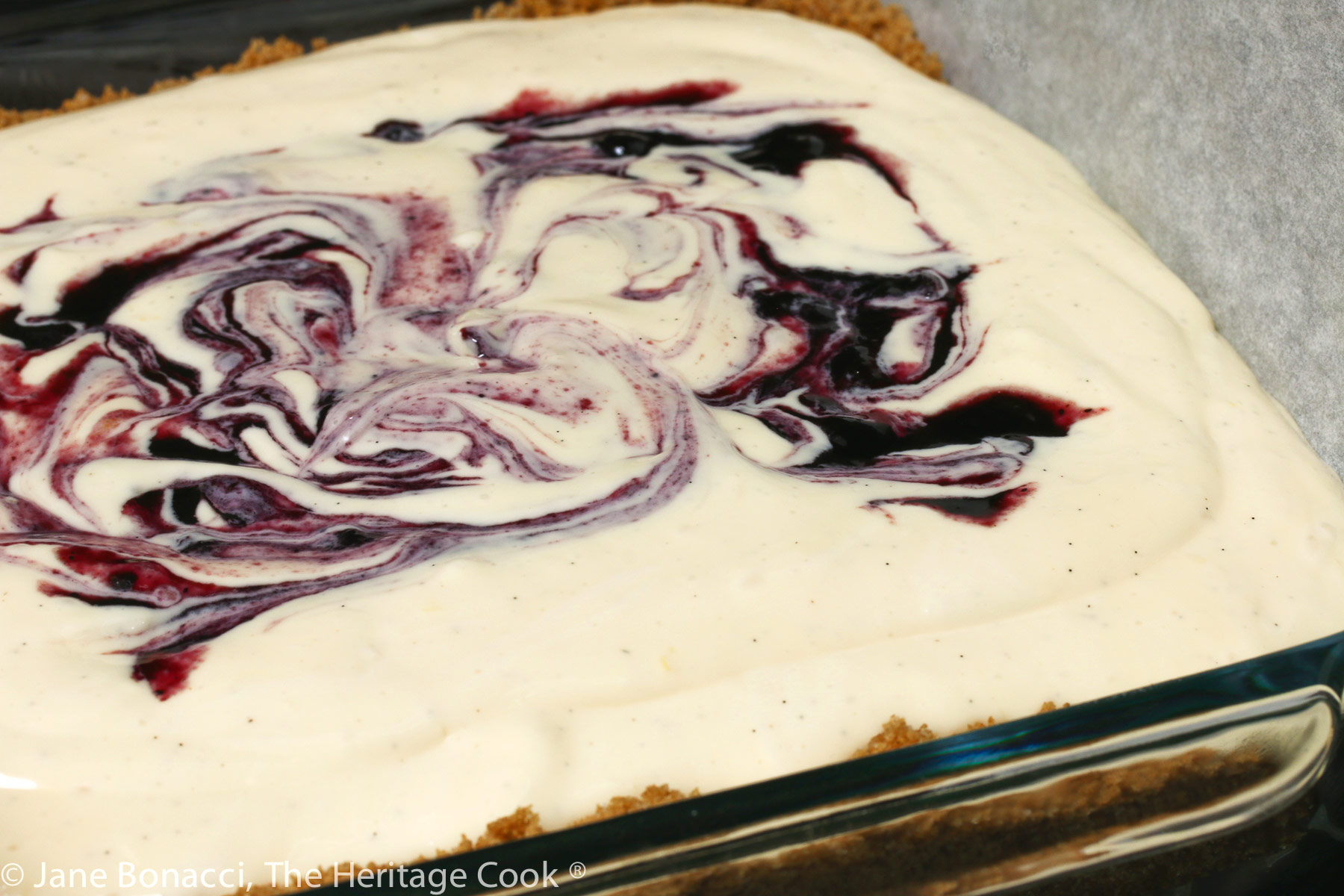 Swirls of blueberry jam on top of cheesecake filling before baking. 