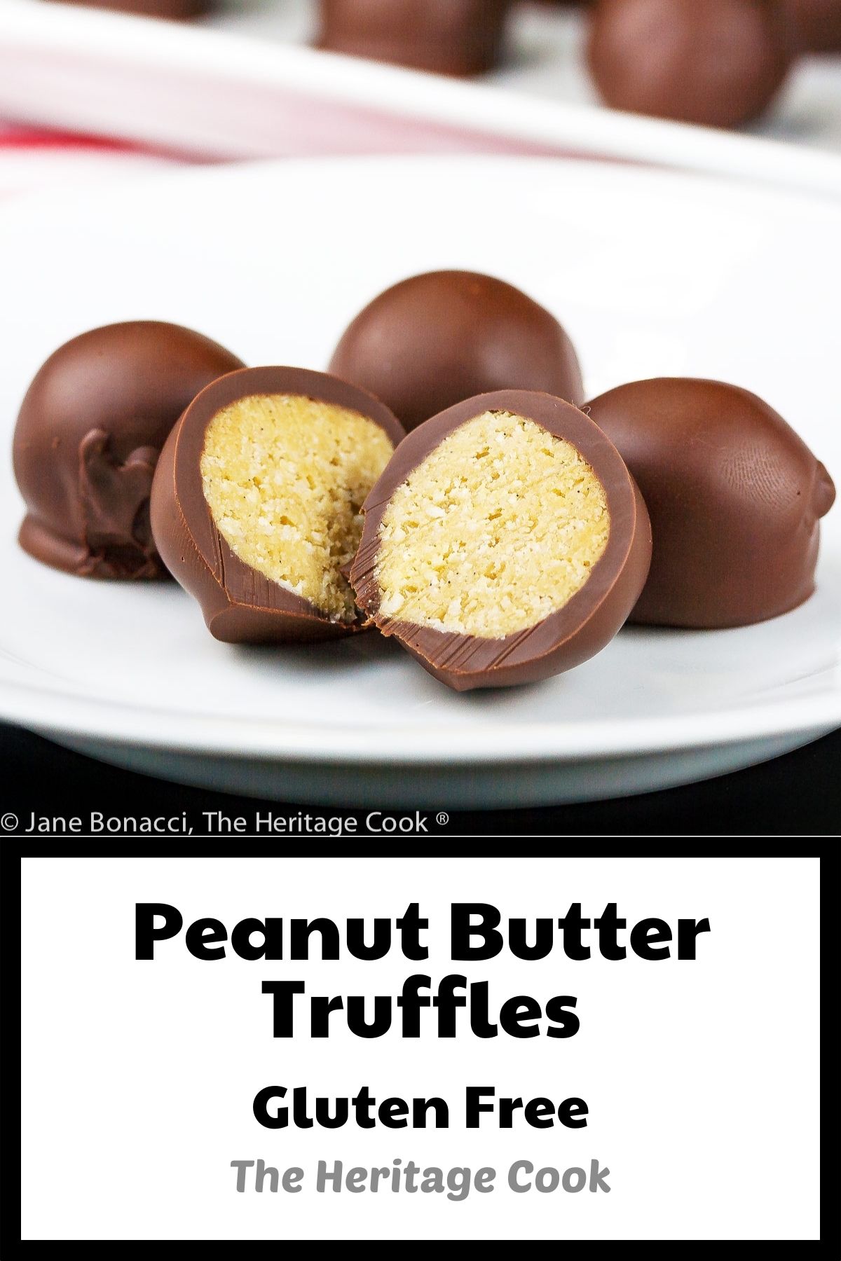 Chocolate Peanut Butter Truffles are balls of sweetened peanut butter filling coated in dark chocolate, some cut open to show the centers, on a white tray or plate on top of red striped towels © 2023 Jane Bonacci, The Heritage Cook. 