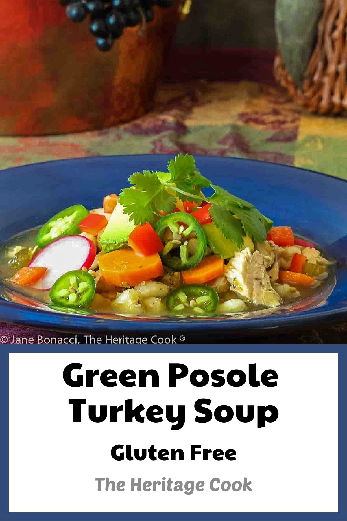 Large bowl of green posole turkey soup topped with your choice of garnishes, sitting on a festive harvest colored cloth; I used cilantro, limes, avocado, red bell pepper, and radishes for brightness and interest © 2023 Jane Bonacci, The Heritage Cook. 