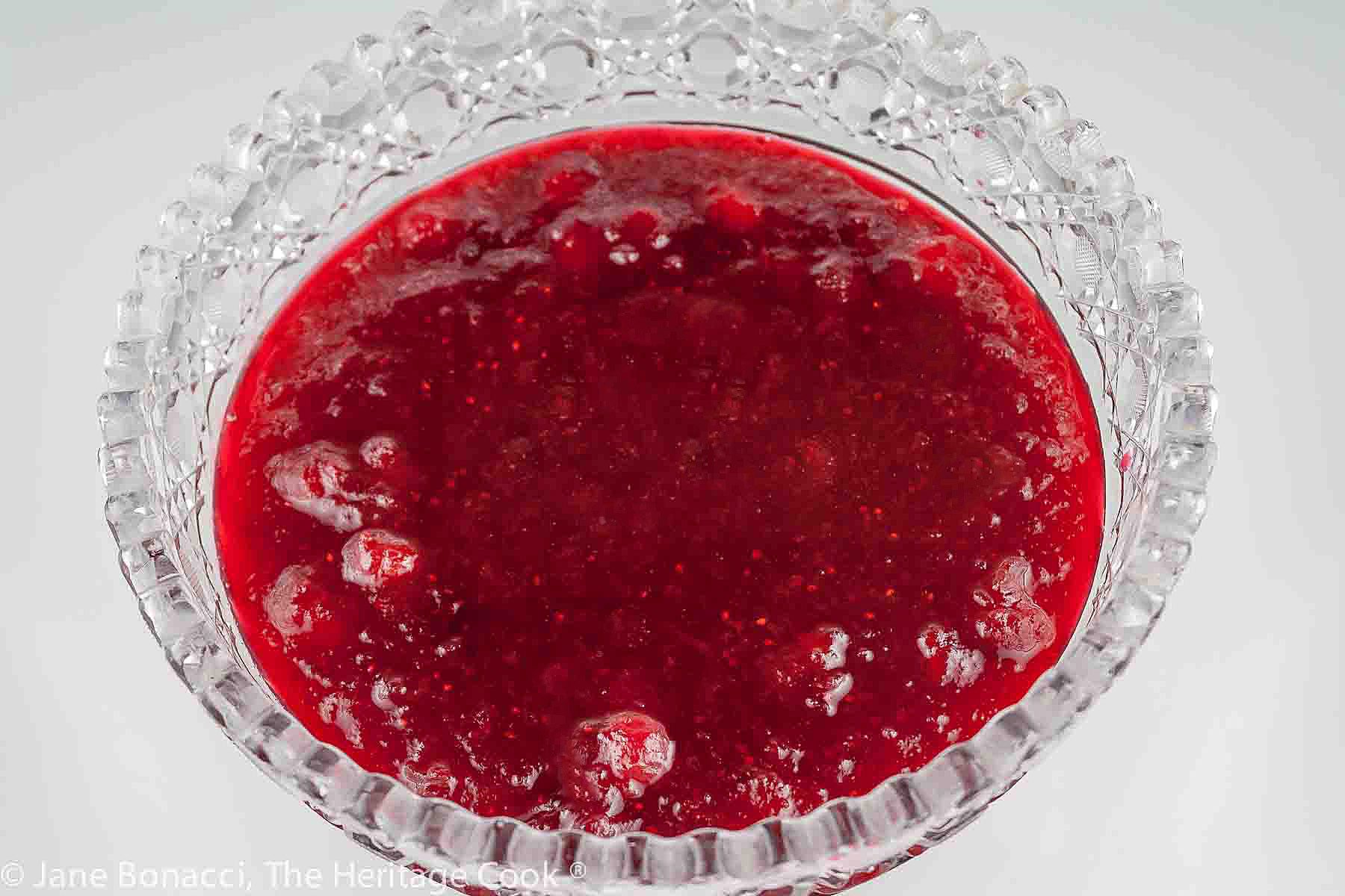 Simple Homemade Cranberry Sauce is displayed and served in a cut glass serving bowl which makes the beautiful red color sparkle © 2023 Jane Bonacci, The Heritage Cook. 