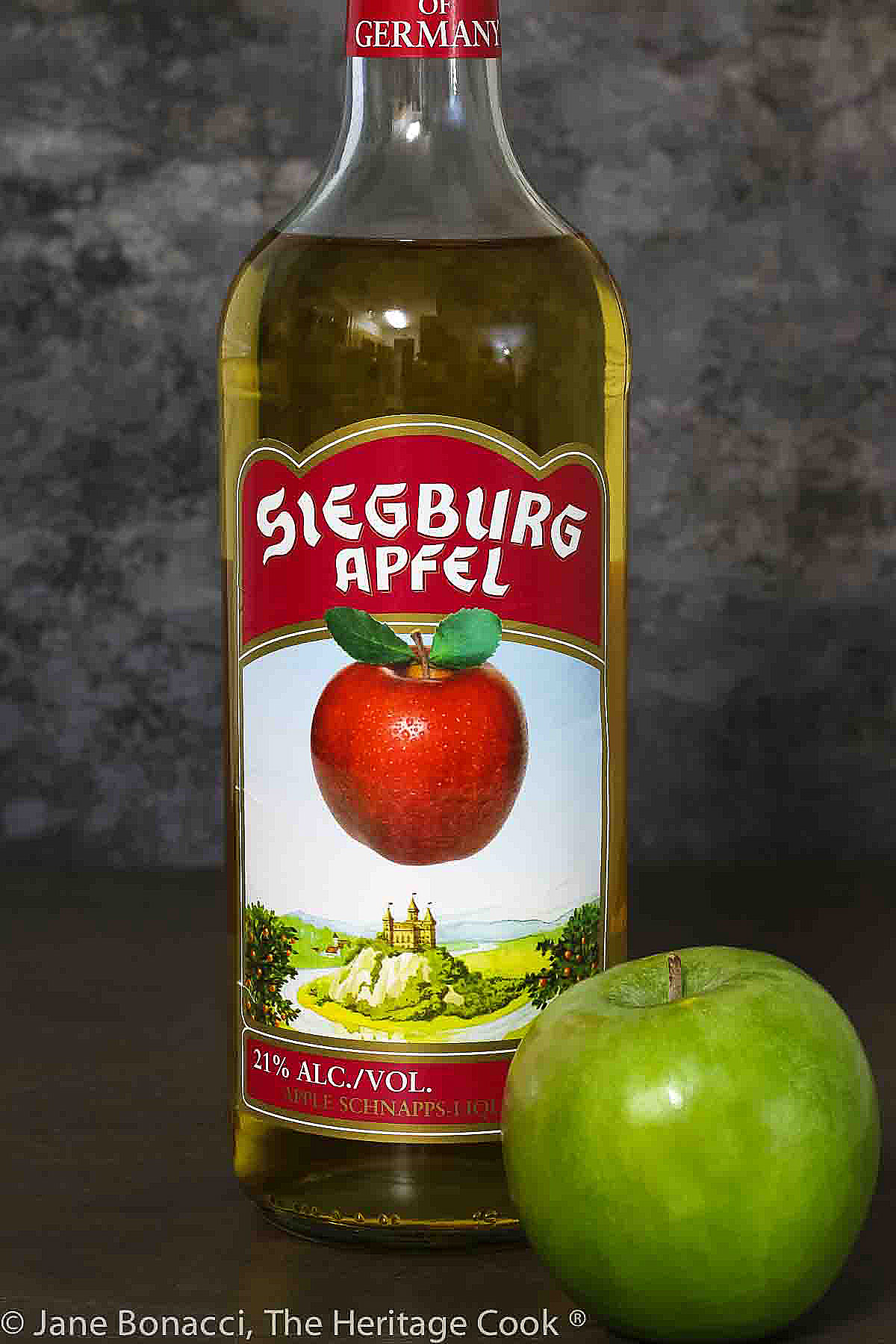 Bottle of apple schnapps to be used in the glaze and a green apple. 