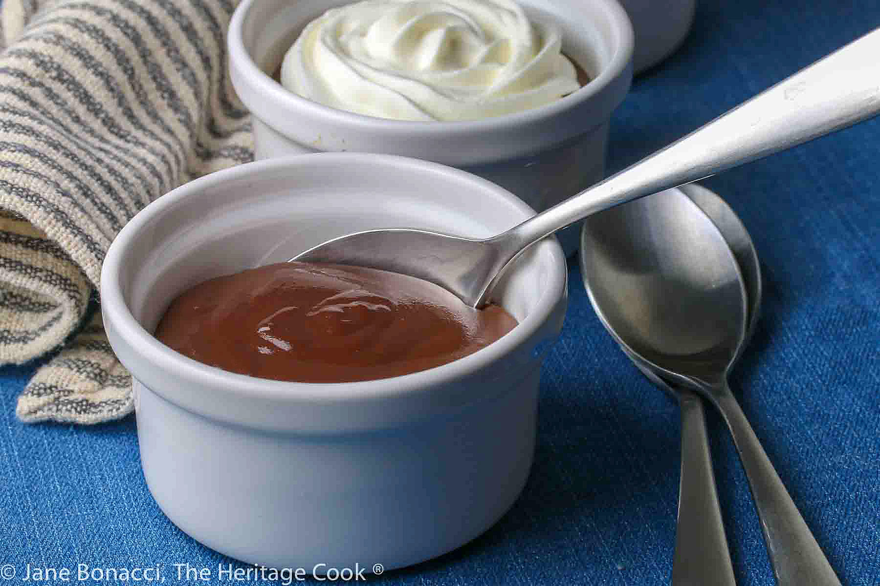 Single ramekin without whipped cream with a spoon tucked into the back of the ramekin. 