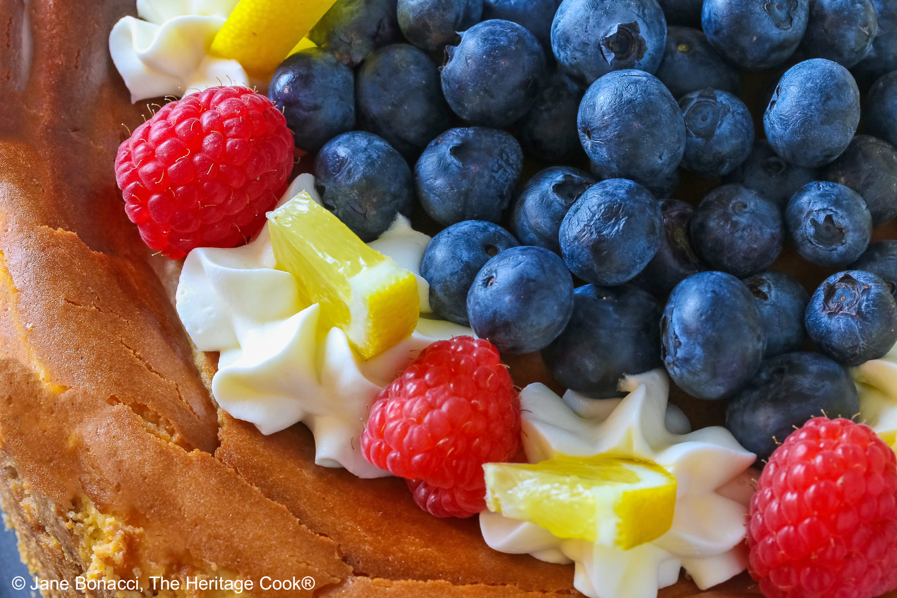 Close up of the top of the cheesecake, focused on the fruit toppings. 