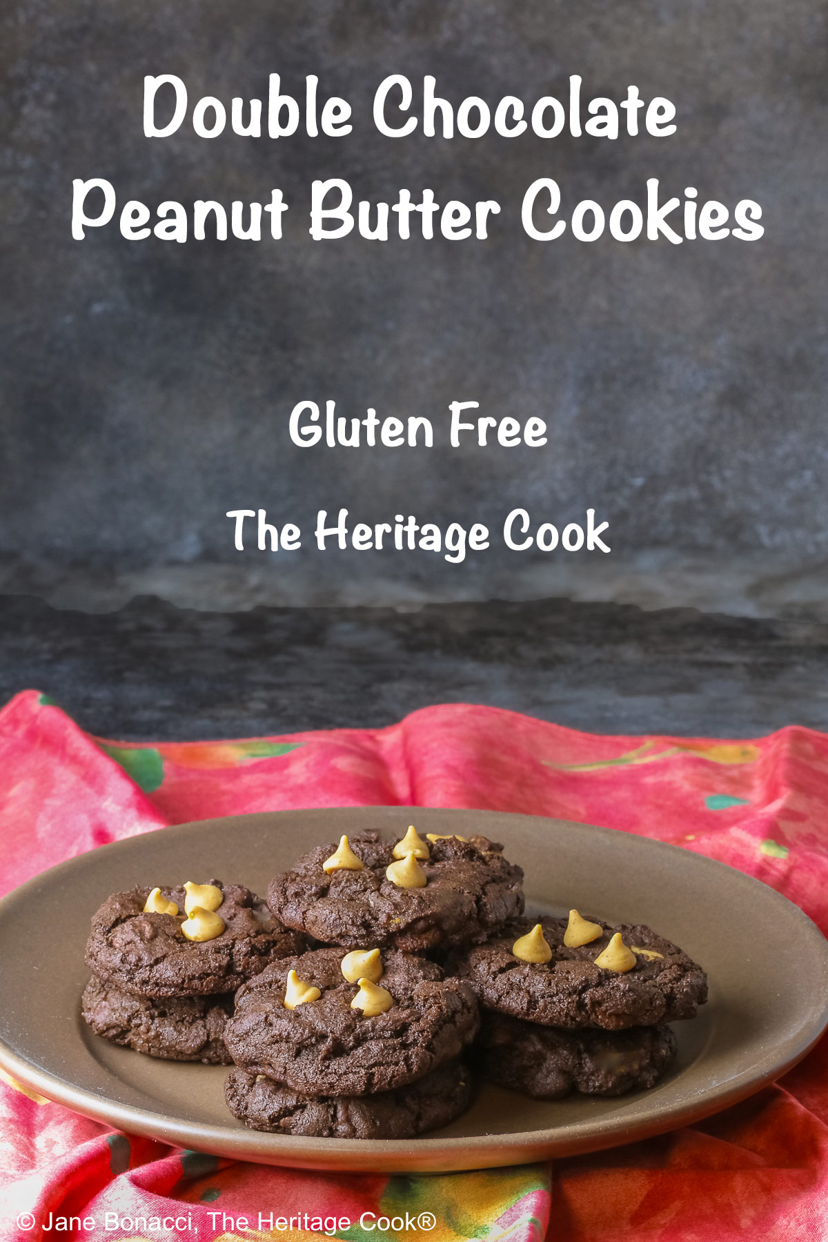 Four stacks of black Double Chocolate Peanut Butter Cookies with light peanut butter chips on top on a deep brown ceramic plate sitting on a bright pink cloth © 2025 Jane Bonacci, The Heritage Cook.