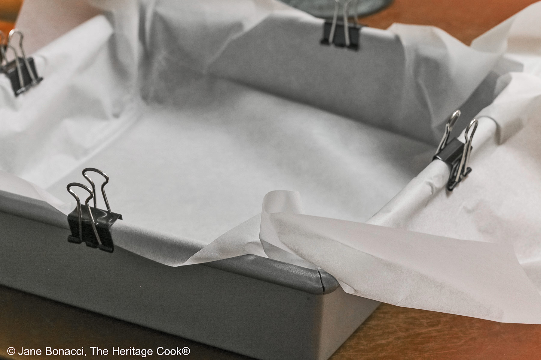 Parchment sling in the baking pan and held in place with metal binder clips.