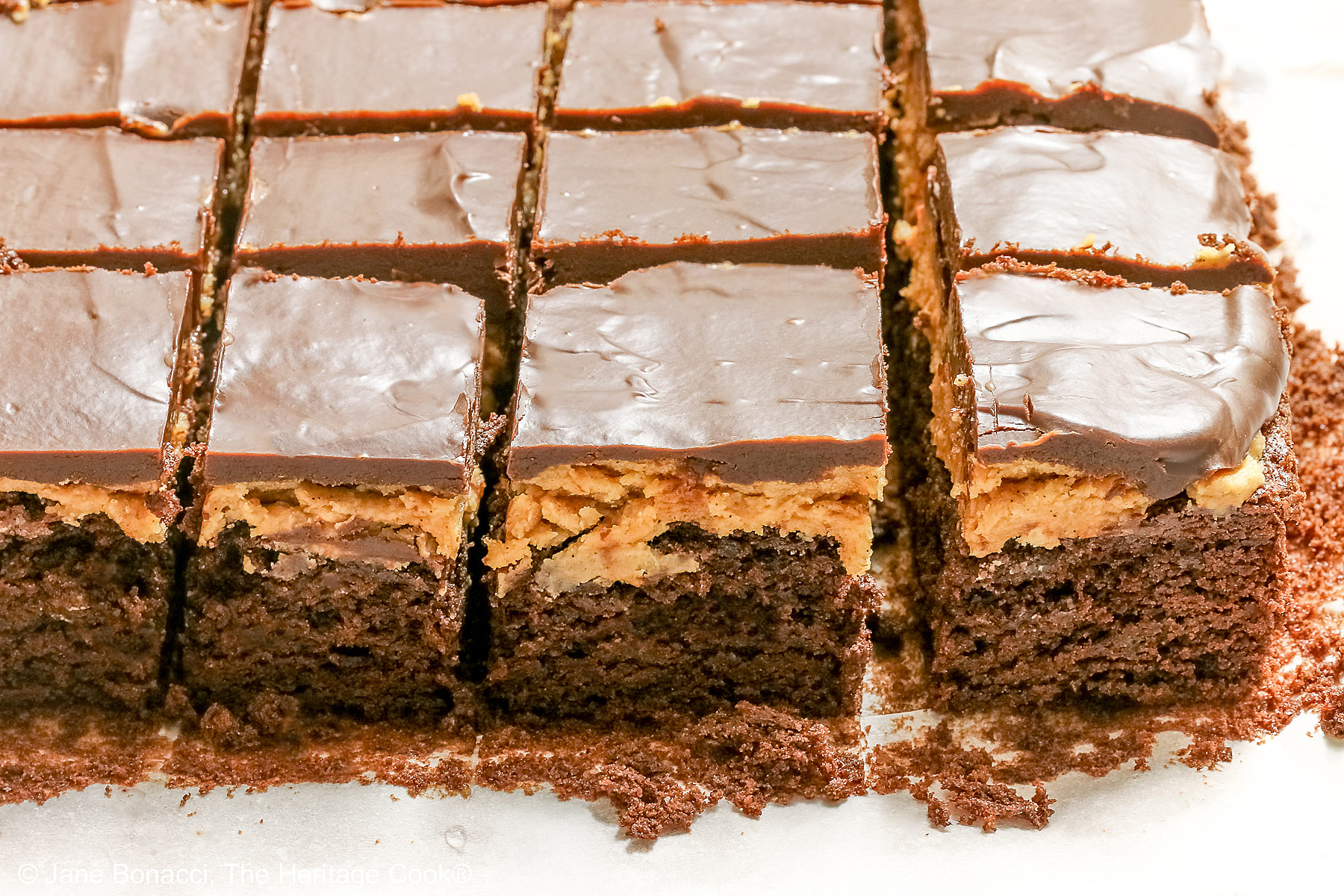 Sliced layered peanut butter brownies on the cutting board. 