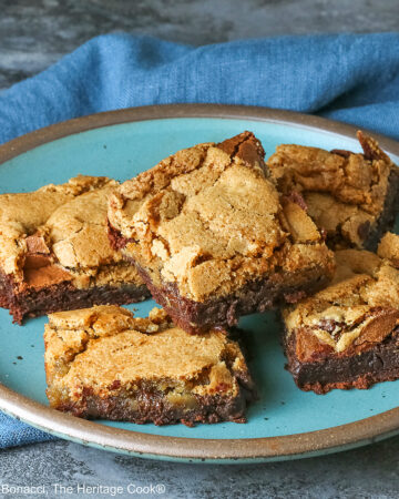 5 stacked Double Chocolate Brookies sitting on a turquoise colored plate with a medium blue cloth behind, on a mottled gray background © 2025 Jane Bonacci, The Heritage Cook.