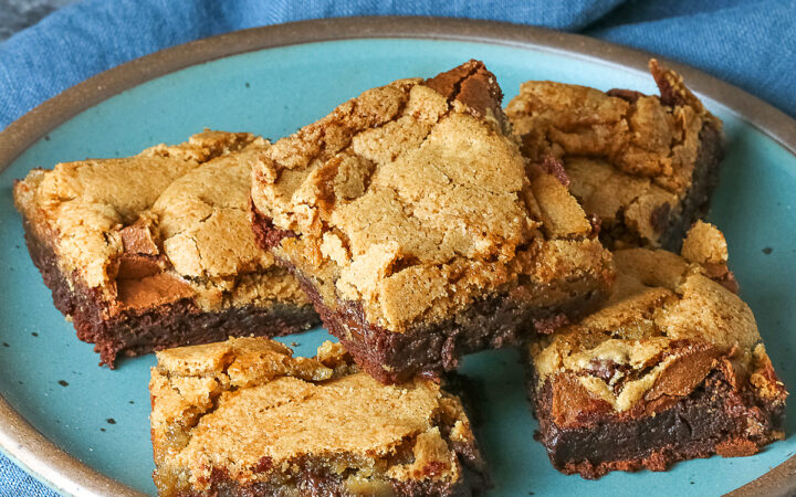 5 stacked Double Chocolate Brookies sitting on a turquoise colored plate with a medium blue cloth behind, on a mottled gray background © 2025 Jane Bonacci, The Heritage Cook.