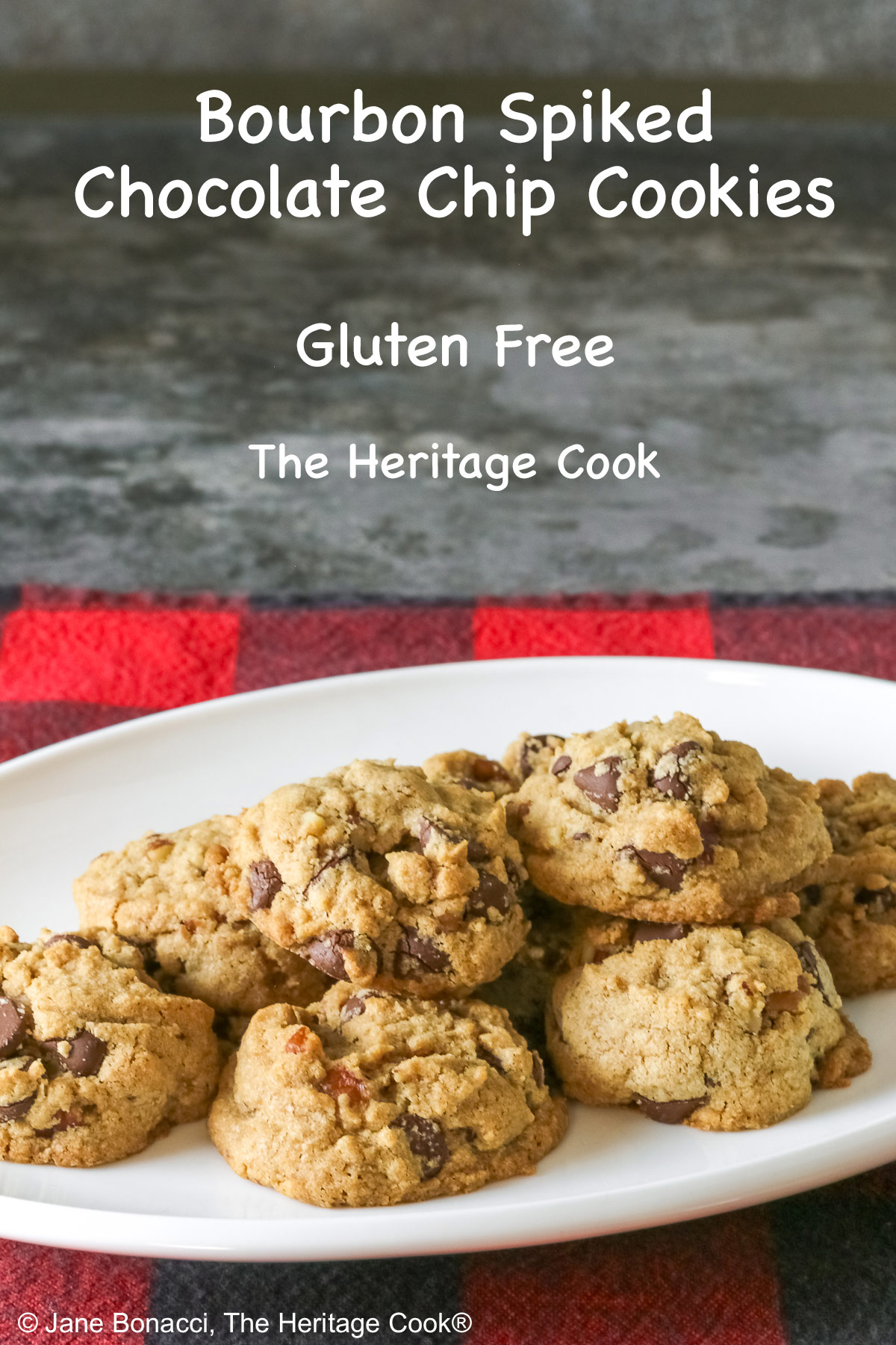 Elongated pile of Bourbon Spiked Chocolate Chip Cookies on a small white oval platter, sitting on a red and black checked buffalo plaid cloth © 2025 Jane Bonacci, The Heritage Cook.