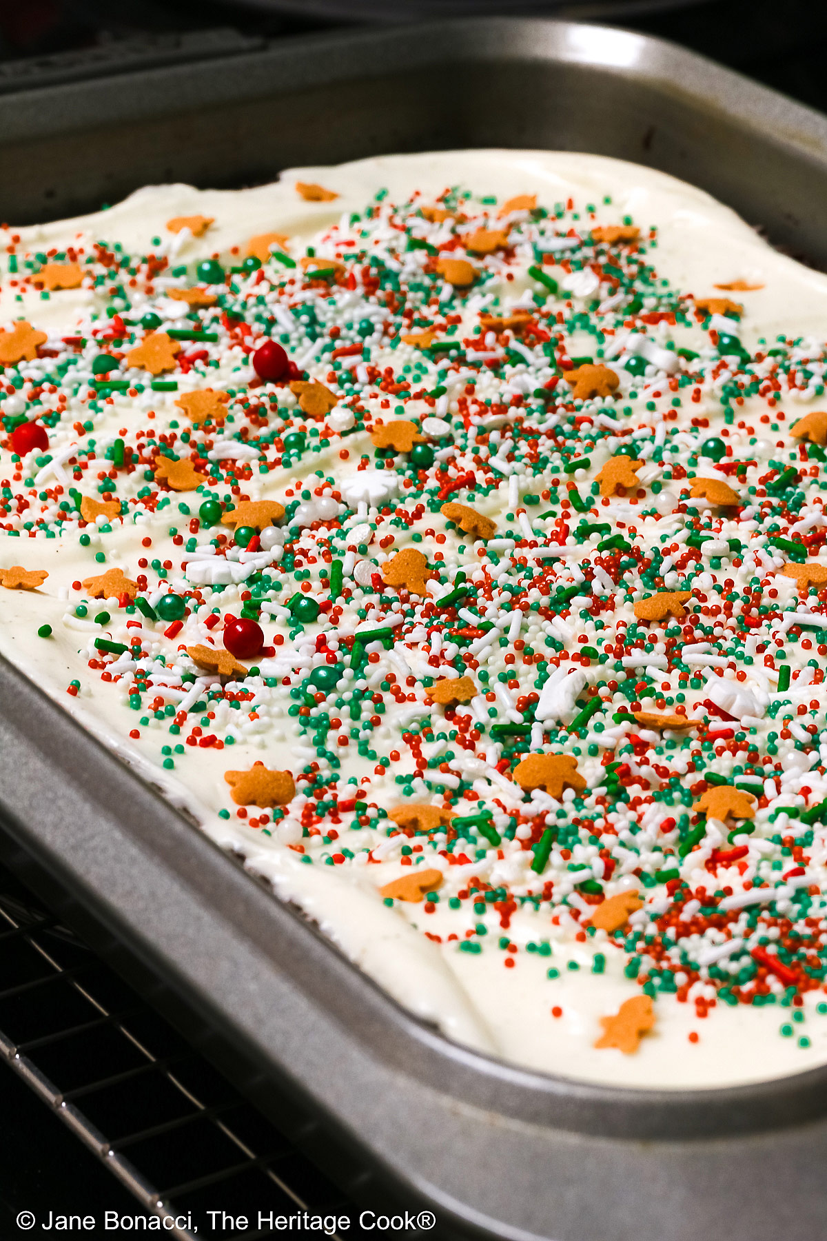 Whole pan of frosted Gingerbread Brownies decorated with holiday sprinkles.