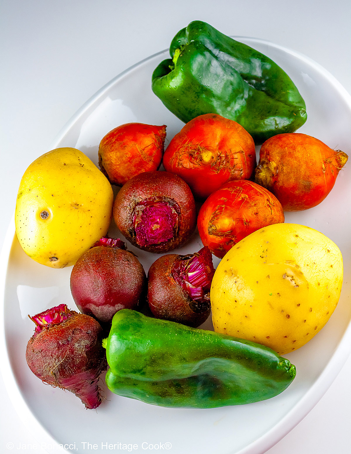 Platter of mixed vegetables, brightly colored on a white plate.