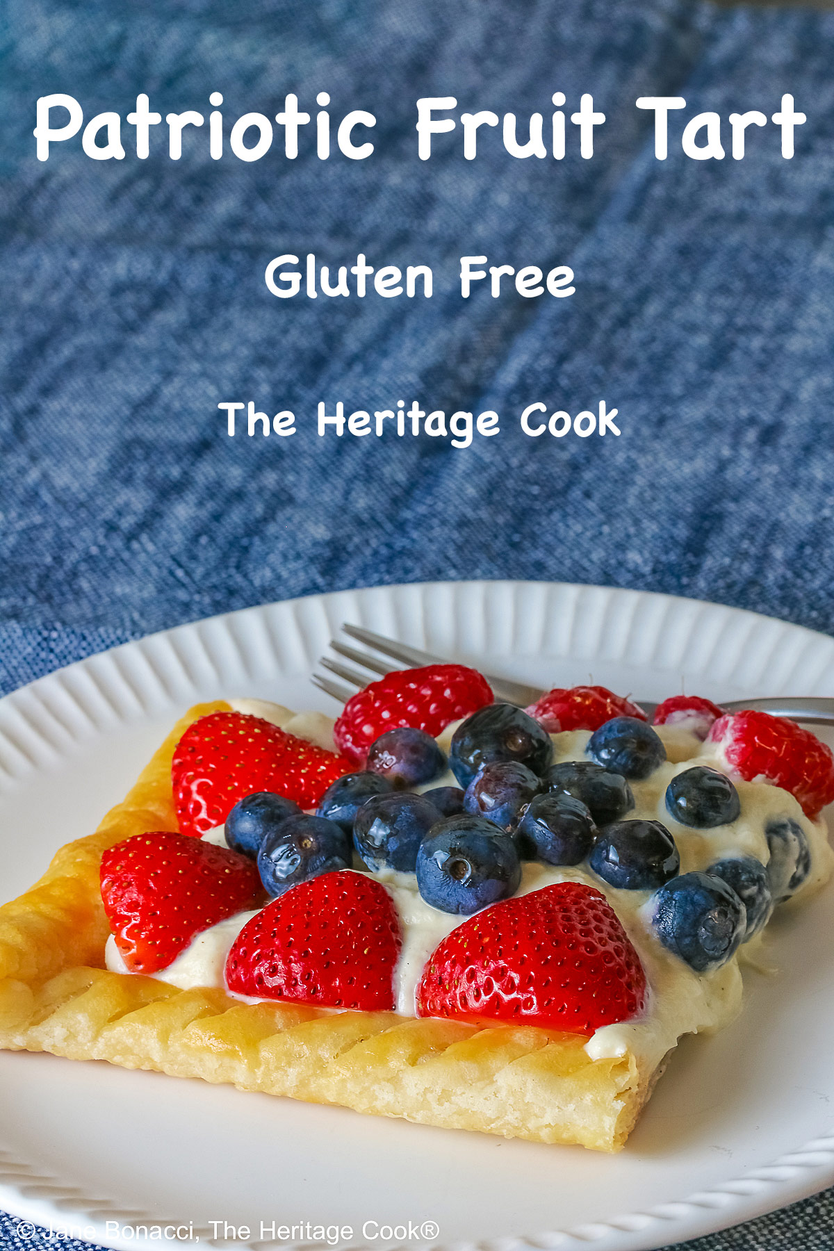 This Patriotic Fruit Tart is sitting on a deep blue platter, with lines of red strawberries, blueberries, and raspberries on a white chocolate cream filling for a fun holiday dessert for your Memorial Day or 4th of July celebrations; some shots of a single slice on a white plate, ready for eating © 2026 Jane Bonacci, The Heritage Cook.