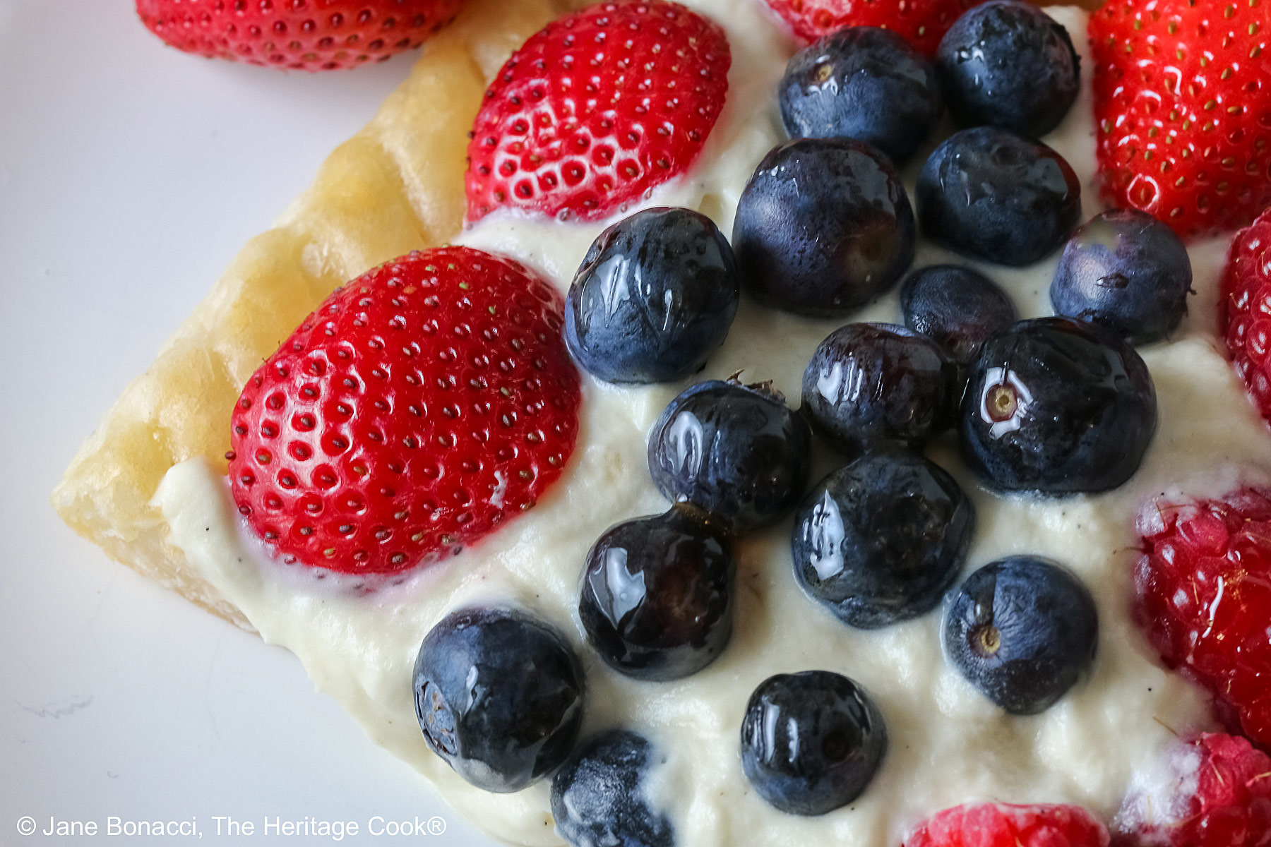 Beautiful slice of Patriotic Fruit Tart with white chocolate cream filling.