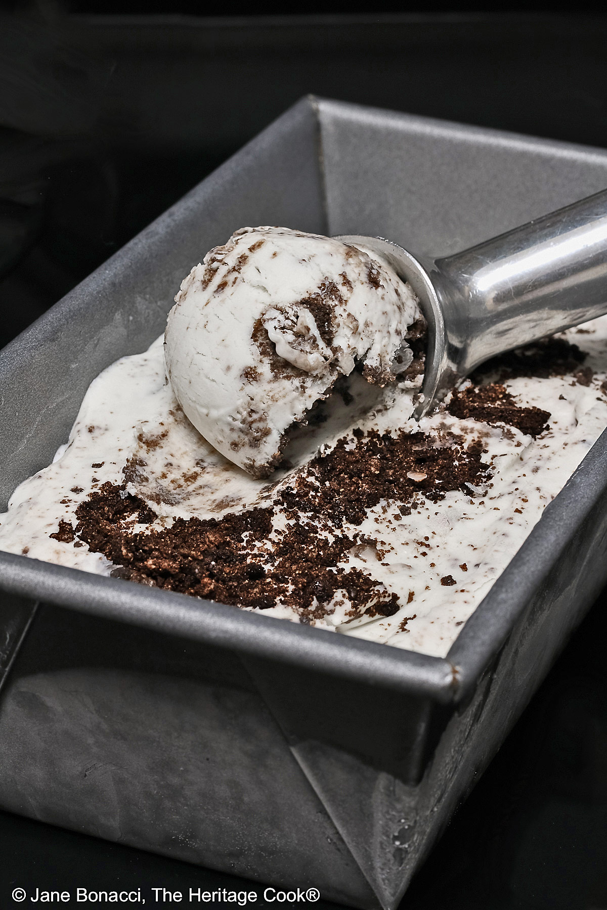 A scoop of ice cream being formed in a loaf pan.