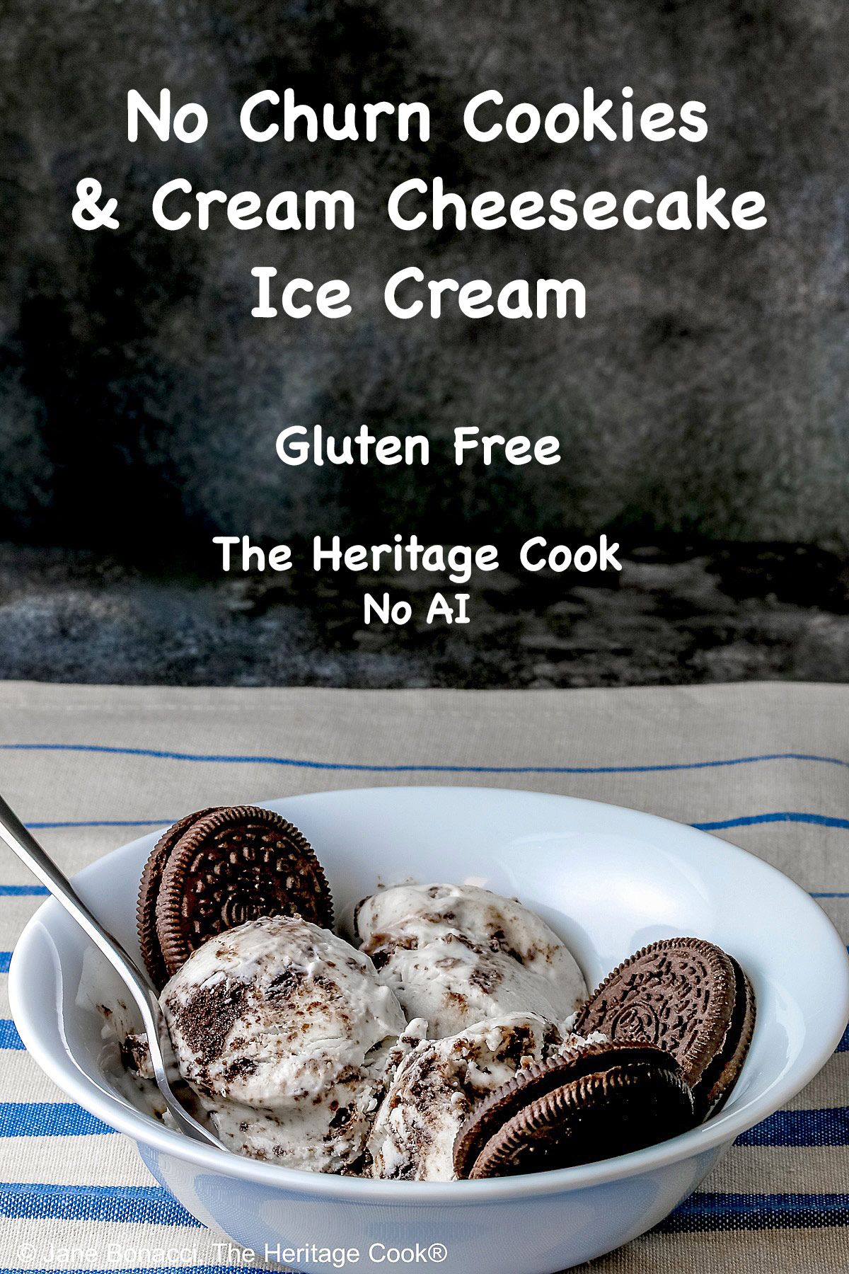 White bowl filled with 3 scoops of No Churn Cookies and Cream Cheesecake Ice Cream with several whole cookies tucked into the bowl and a spoon resting alongside one of the scoops, sitting on a blue and white striped cloth © 2026 Jane Bonacci, The Heritage Cook.