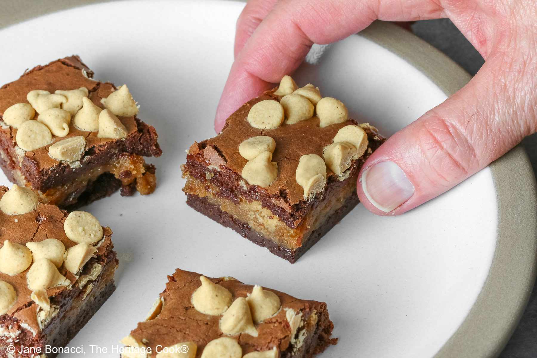 Man's hand reaching to steal a peanut butter brownie.