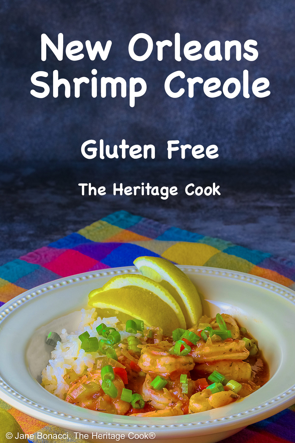 Pale yellow bowl filled with long grain rice topped with New Orleans Shrimp Creole topped with perfectly cooked shrimp, sprinkled with sliced green onions and minced red bell peppers, with 3 wedges of fresh lemon © 2026 Jane Bonacci, The Heritage Cook.