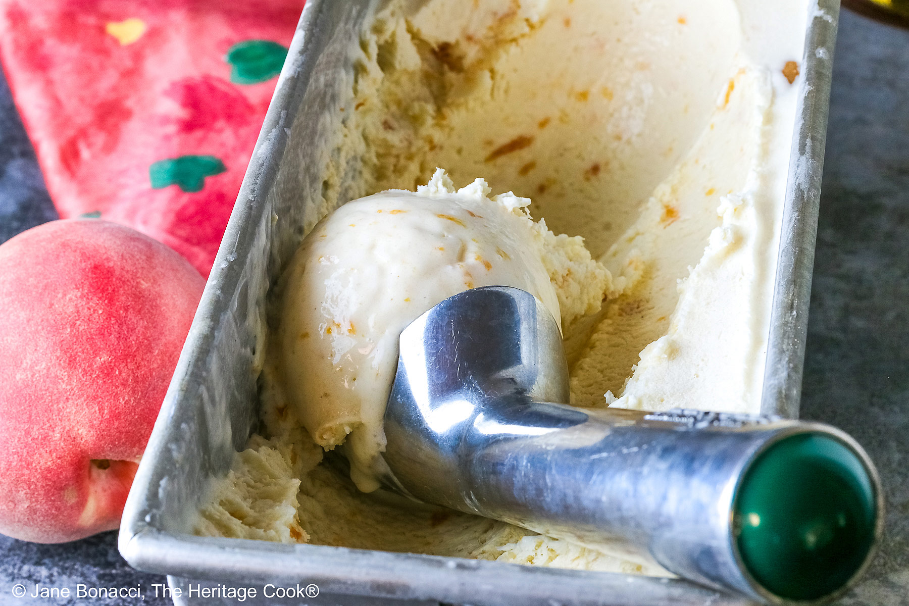Peach Cobbler Ice Cream in an ice cream scoop in the loaf pan.
