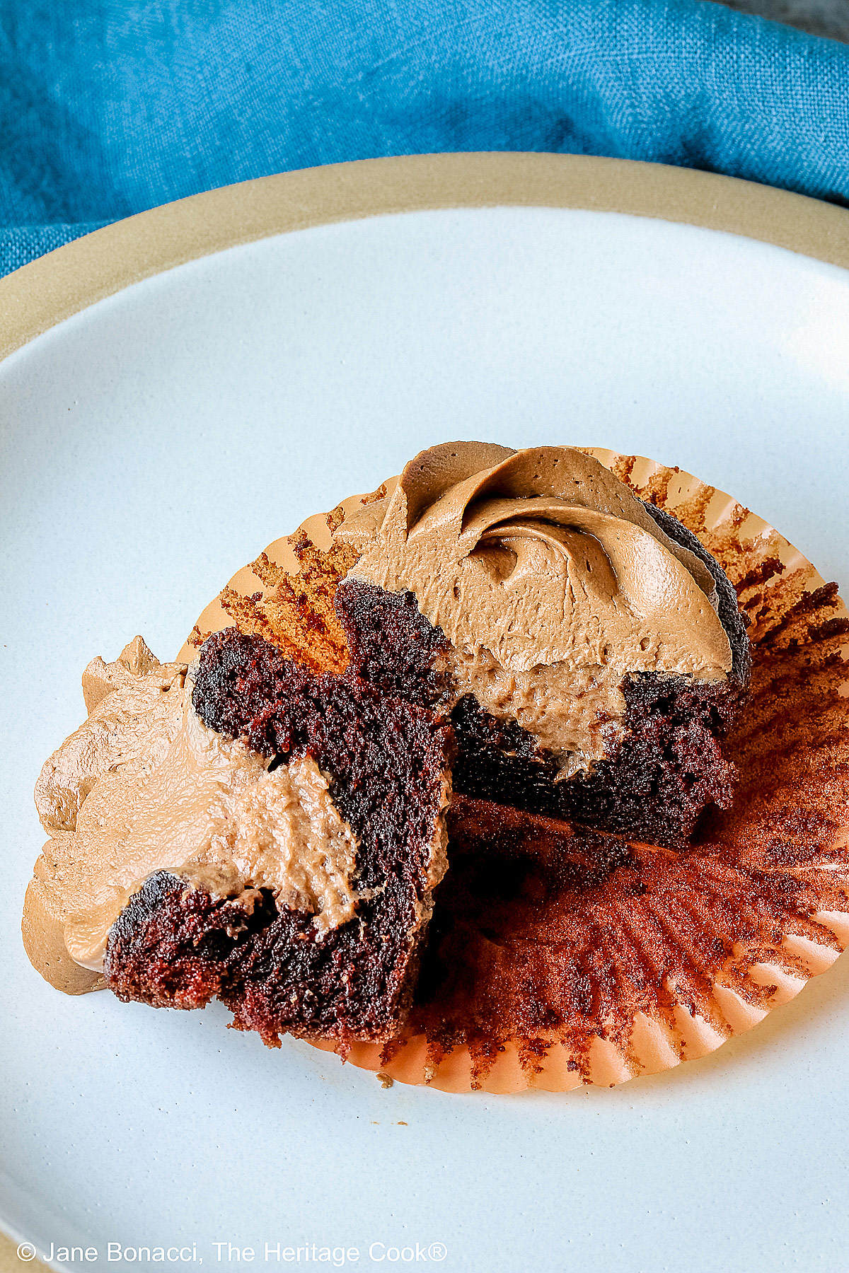 One cupcake cut in half to show the mousse filling and frosting.